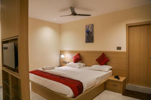 a bedroom with a bed and a flat screen tv at Lumis studio apartment in Hyderabad