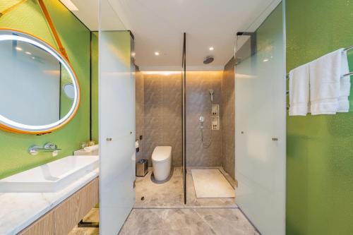 a bathroom with a shower and a sink and a mirror at Holiday Inn Zhuhai City Center by IHG in Zhuhai