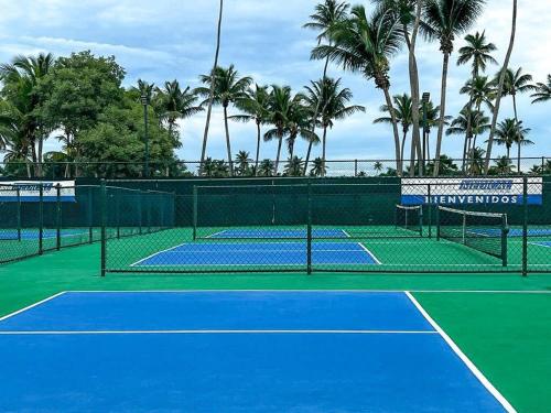 a tennis court with palm trees in the background at Villa Brisas del Mar-Ocean View, Gated Community in Dorado