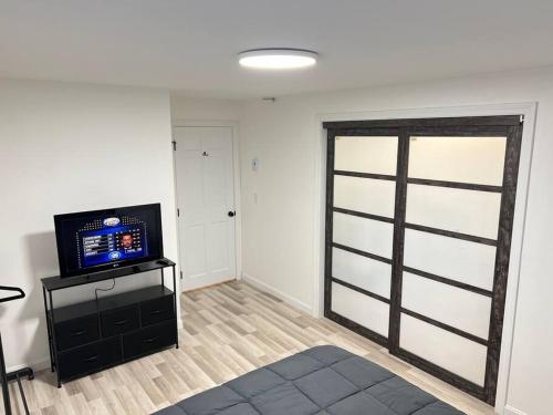 a living room with a television and a sliding door at 5min Gillette Stadium! Sleeps 12 in Norfolk