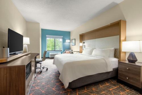 a hotel room with a bed and a flat screen tv at Holiday Inn Cheshire - Southington by IHG in Southington