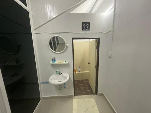 une petite salle de bain avec un lavabo et un miroir dans l'établissement MEGIE HOMESTAY PREMIER BETONG Thailand, à Betong