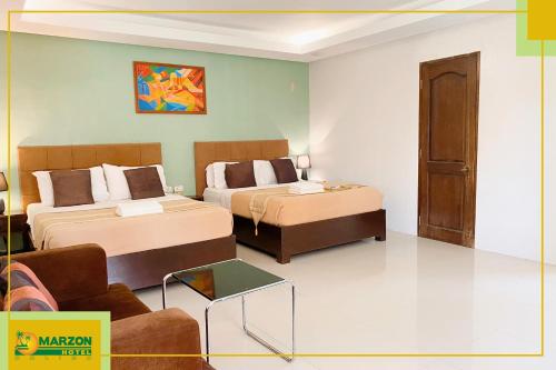 a hotel room with two beds and a couch at MARZON HOTEL KALIBO in Kalibo