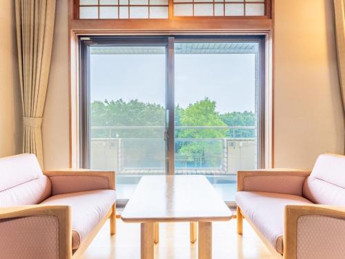 a waiting room with couches and a table in front of a window at LiVEMAX Resort Upopoi Shiraoi Onsen in Shiraoi