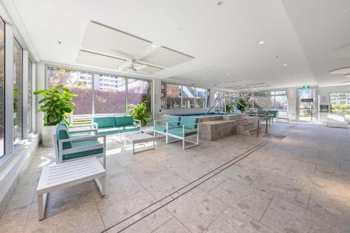 a lobby with chairs and tables and windows at ULTIQA Beach Haven on Broadbeach in Gold Coast