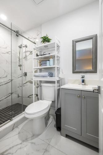 a white bathroom with a toilet and a shower at Cozy Apartment with a luxury King Bed in Miami Gardens