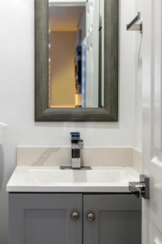 a bathroom with a white sink and a mirror at Cozy Apartment with a luxury King Bed in Miami Gardens