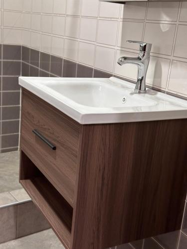 a bathroom with a white sink and a wooden cabinet at Short term rental in Accra