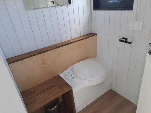 a small bathroom with a toilet in a room at Avon Cabin by Tiny Away in Huiroa