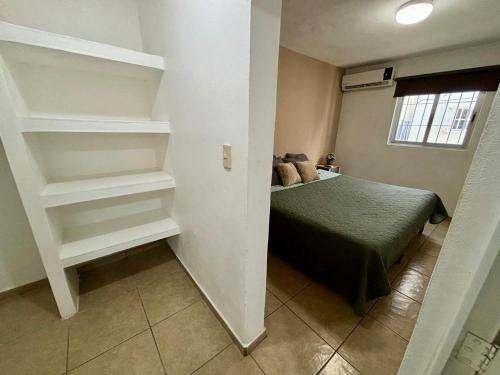 a bedroom with a bed and shelves in a room at Centrico, Cama King Size & Cocina Cerca de la UAS in Lima del Alto