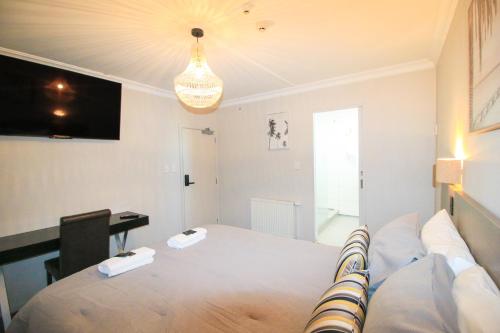 a living room with a bed and a desk at Whitehouse Hotel in Invercargill