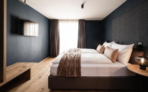 a bedroom with a large bed and a window at The Post Mountain Residence in Dobbiaco