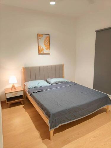 a bedroom with a bed and a night stand with a lamp at Maya Bay Gamuda Cove Splash Mania near KLIA and Cyberjaya in Pulau Kempas