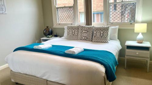 a bedroom with a large bed with two towels on it at Bay Escape in Nelson Bay
