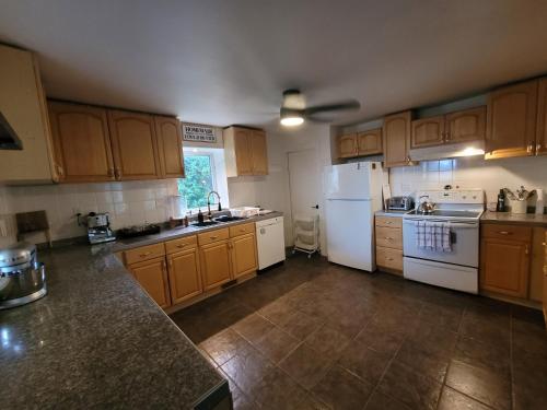 a large kitchen with wooden cabinets and white appliances at Farmhouse in Simcoe