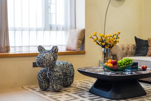 a black and white cat statue sitting next to a table at Guangzhou He She Art Apartment in Guangzhou