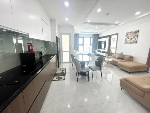 ニャチャンにあるDuc's Oceanus Nha Trang Apartmentのキッチンとテーブルとソファのあるリビングルーム