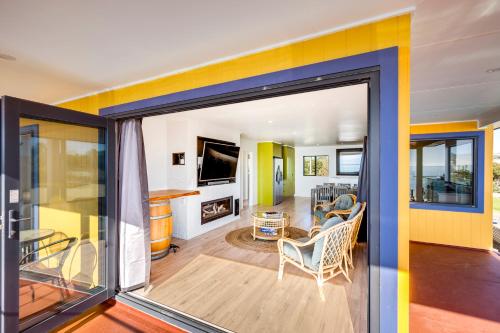 a living room with a large sliding glass door at Coastal Embrace - Te Awanga Seaview Escape in Te Awanga