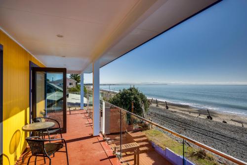 a balcony with chairs and a view of the beach at Coastal Embrace - Te Awanga Seaview Escape in Te Awanga