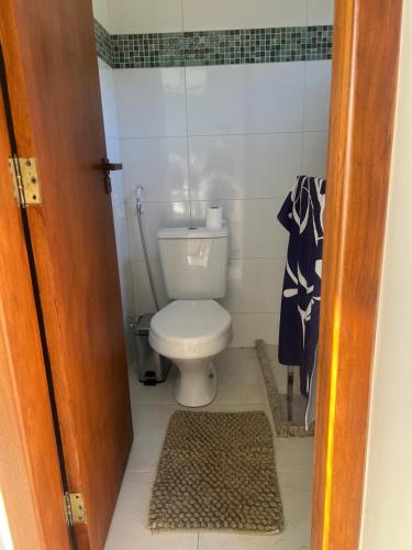 a small bathroom with a toilet and a rug at Fazenda Monte Esperança in Guapimirim
