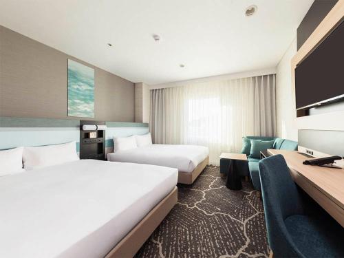 a hotel room with two beds and a desk at JR-East Hotel Mets Kamakura Ofuna in Kamakura