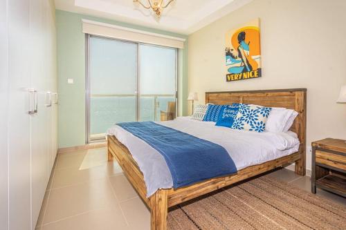 a bedroom with a bed and a large window at Contemporary Full Ocean View Apartment in Ras al Khaimah