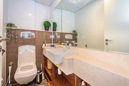 a bathroom with a sink and a toilet and a mirror at Contemporary Full Ocean View Apartment in Ras al Khaimah