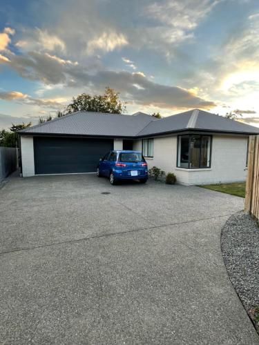 a house with a blue car parked in a driveway at Bryndwr Accommodation in Christchurch