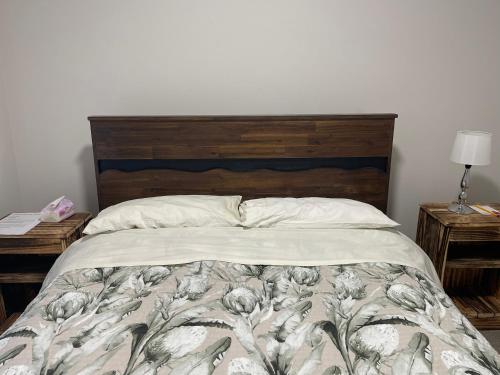 a bedroom with a bed with a wooden headboard at Bryndwr Accommodation in Christchurch