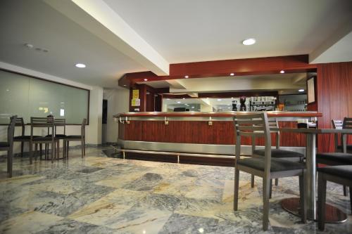 サンティアゴ・デ・コンポステーラにあるホテル ウィンザーの椅子とテーブルのあるレストランのバー