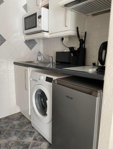 une cuisine avec un lave-linge et un micro-ondes dans l'établissement studio standing cannes croisette, à Cannes