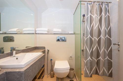 een badkamer met een wastafel, een toilet en een douche bij Oceanfront Coastal Apartment in Ras al Khaimah