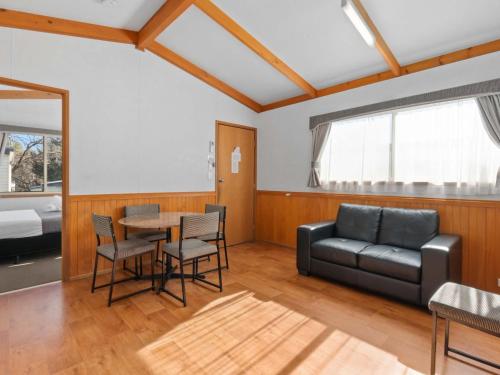 a living room with a couch and a table and chairs at Southside Village in Canberra