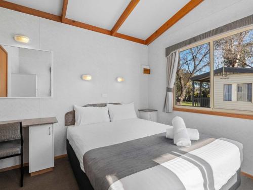 a bedroom with a large bed and a window at Southside Village in Canberra