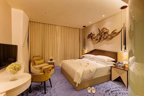 a bedroom with a bed and a desk and a chair at Cinnamon Life at City of Dreams in Colombo