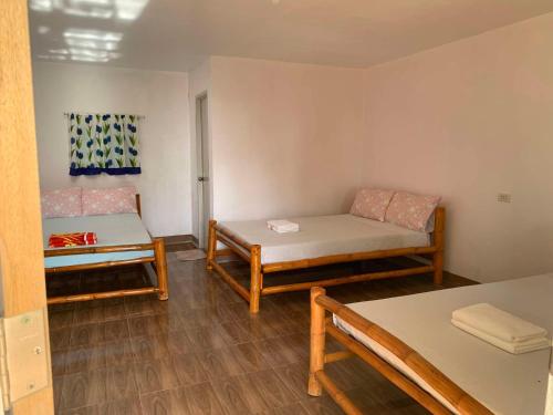 una stanza con un letto, un divano e un tavolo di palanas white sand beach resort a Himensulan