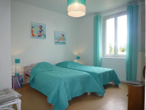 a blue bedroom with a bed and a window at Appartement Hello in Metz