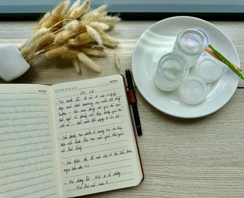 a book on a table with a plate of food at Sophia Healing House Cần Thơ in Can Tho