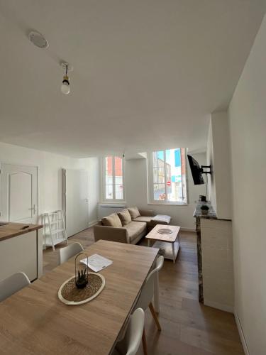 un salon avec une table et un canapé dans l'établissement Appartement moderne centre ville, à Saint-Dizier