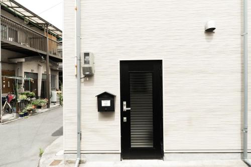 a black door on the side of a building at 楓の宿 Osaka Midoribashi5min 5ppl liubj8 in Osaka