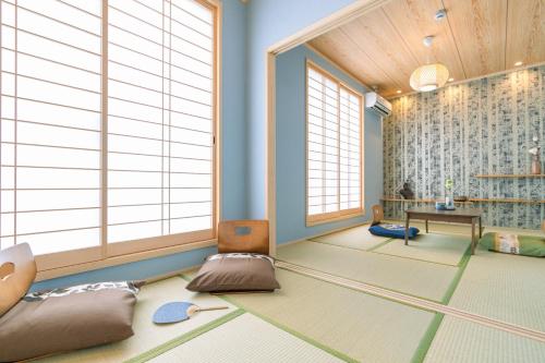 a room with large windows and a room with a table at 楓の宿 Osaka Midoribashi5min 5ppl liubj8 in Osaka