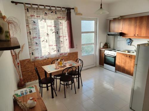 kuchnia ze stołem, krzesłami i lodówką w obiekcie Hibiscus Green Apartments w mieście Afandu