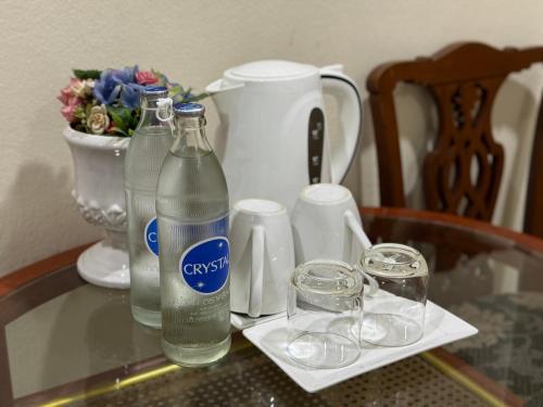 a glass table with bottles and glasses on it at JL Bangkok Hotel in Bangkok