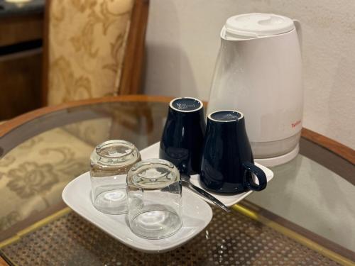 a table with a blender and two glasses on it at JL Bangkok Hotel in Bangkok