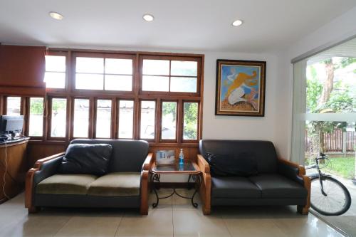 a living room with two couches and a table at JL Bangkok Hotel in Bangkok