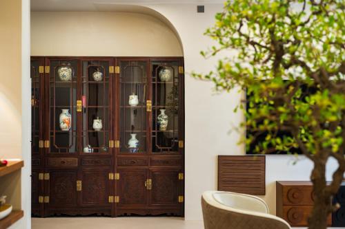 a wooden cabinet with glass doors in a room at Guangzhou He She Art Apartment in Guangzhou