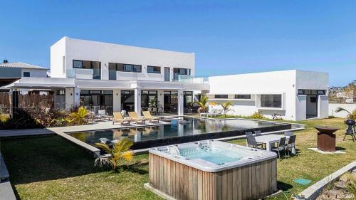 a large white house with a swimming pool at La Villa Phoenix in Saint-Pierre