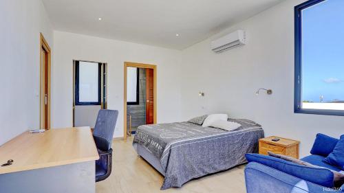 a bedroom with a bed and two chairs and a table at La Villa Phoenix in Saint-Pierre