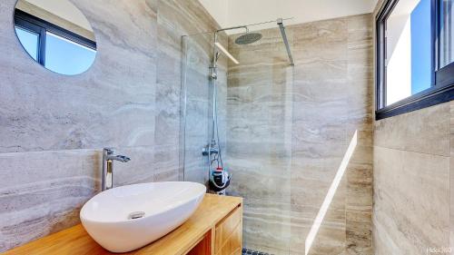 a bathroom with a sink and a glass shower at La Villa Phoenix in Saint-Pierre