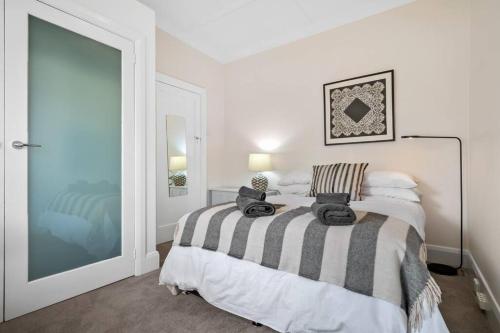 a bedroom with a bed with towels on it at Two Terrific Albert Park Apartments in Albert Park